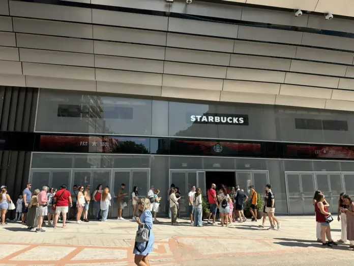 Fachada del nuevo Starbucks en el Santiago Bernabéu durante su inauguración, con aficionados haciendo cola para entrar