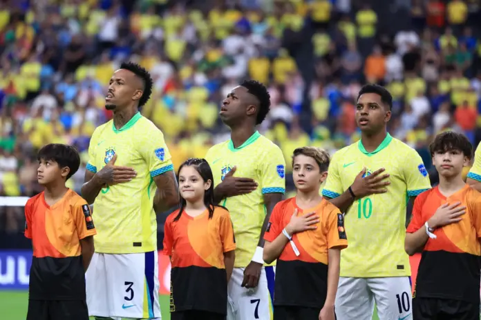 Militao, Vinicius y Rodrygo escuchan el himno de Brasil.