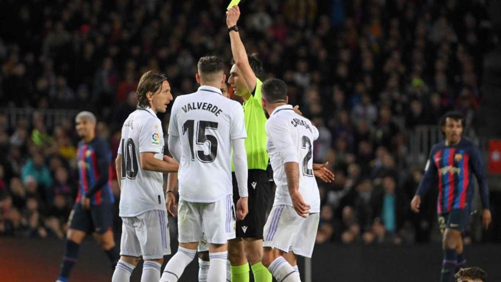 De Burgos Bengoetxea, en su último Clásico entre el Madrid y el Barcelona, mostrando una amarilla a Luka Modric.