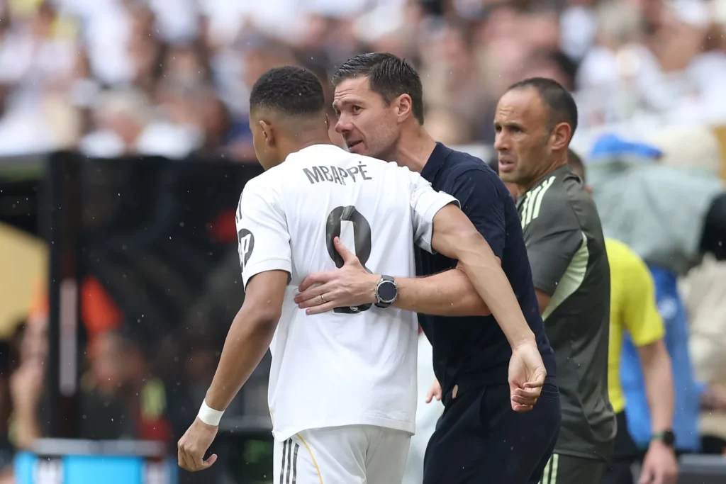 Mbappé y Xabi Alonso hablan durante su etapa en el Real Madrid.