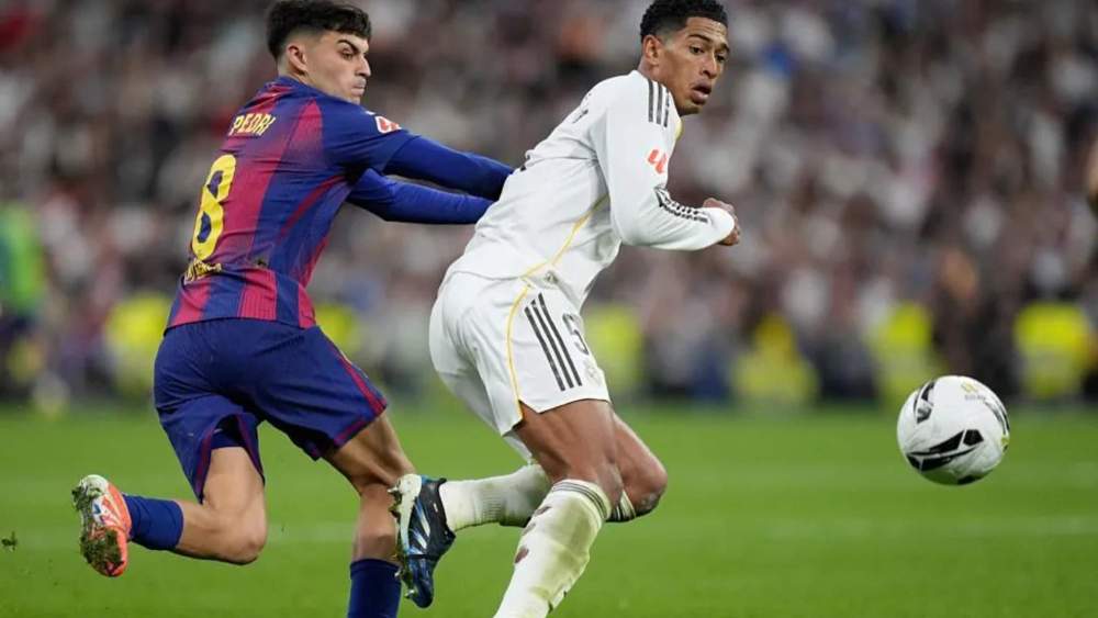 Jude Bellingham y Pedri, en la lucha por un balón, durante el encuentro entre el Madrid y el Barça de esta tarde. Jude Bellingham y Pedri, en la lucha por un balón, durante el encuentro entre el Madrid y el Barça de esta tarde.