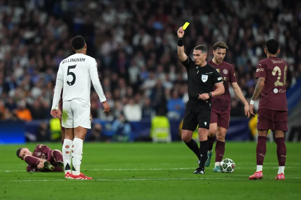 - Qedine El árbitro István Kovács muestra una tarjeta amarilla a Jude Bellingham del Real Madrid.
