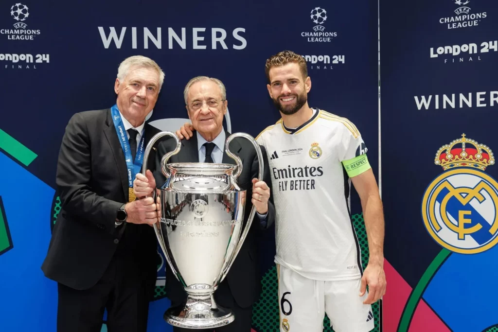 - Qedine Ancelotti posa junto a Florentino y Nacho con el trofeo de campeón de la Champions League en 2024.