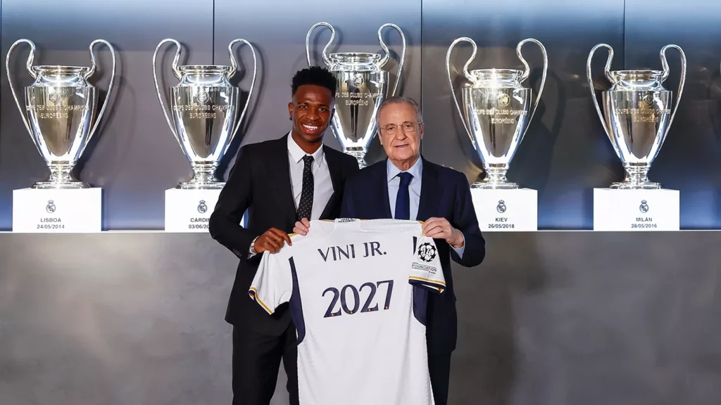 - Qedine Vinicius posa junto a Florentino Pérez, durante su última renovación de contrato con el Real Madrid.