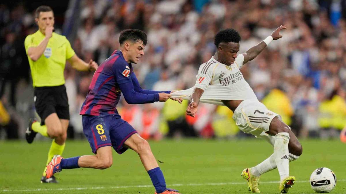 Pedri, agarrando la camiseta de Vinicius Junior en el último Clásico entre el Real Madrid y el Barcelona.