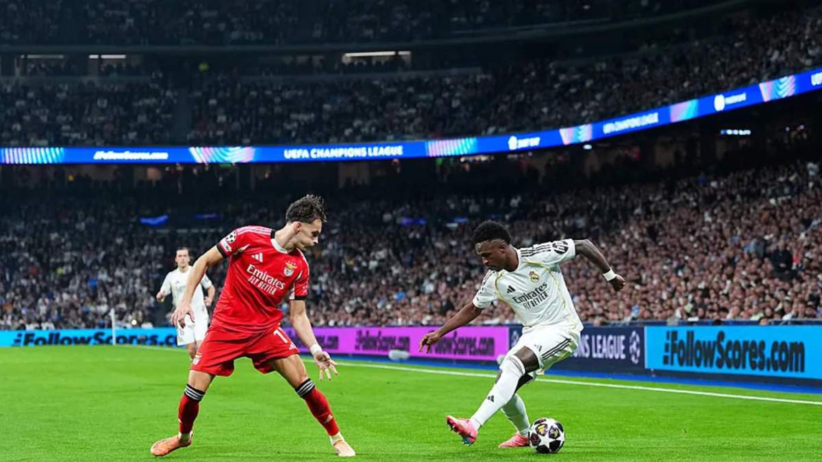 ViniciusJunior, intentando encarar Amar Dedic en un momento del partido entre el Real Madrid y el Benfica en el estadio Santiago Bernabéu.