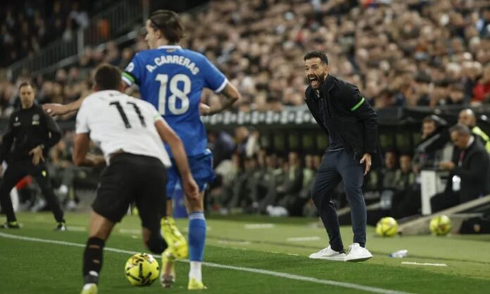 Carlos Corberán, siguiendo el encuentro desde la banda de Mestalla en una jugada entre Álvaro Carreras y Luis Rioja.