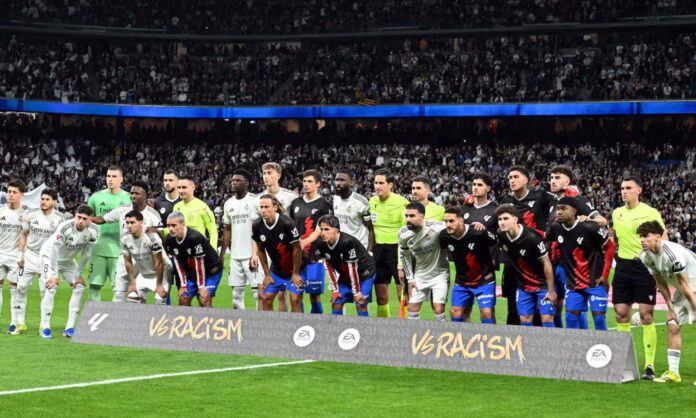 Los jugadores de Real Madrid y Atlético, mostrando su condena del racismo en una campaña de la Liga antes del partido.